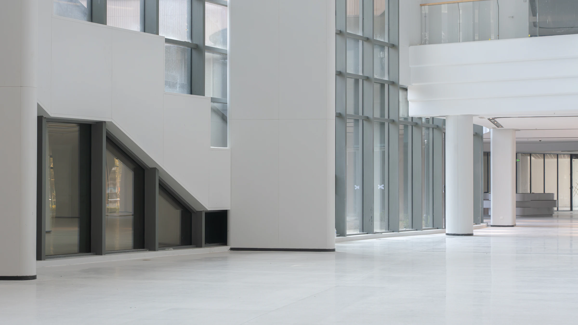 Presvetlená vstupná hala s vysokými oknami a bielymi stĺpmi